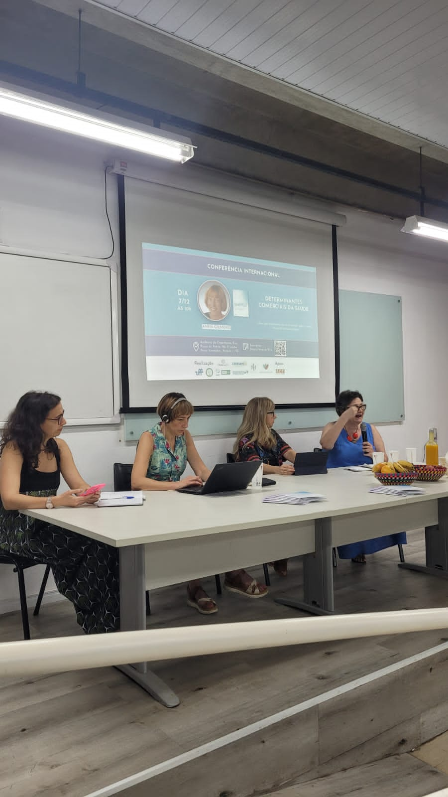 Na foto a mesa de debate da Conferência com a presença da Camila Maranha (ObservaCoI-UFF), Anna Gilmore (University of Bath), Luciene Burlandy (CERESAN-UFF) e Inês Rugani (ObservaCoI-UERJ).